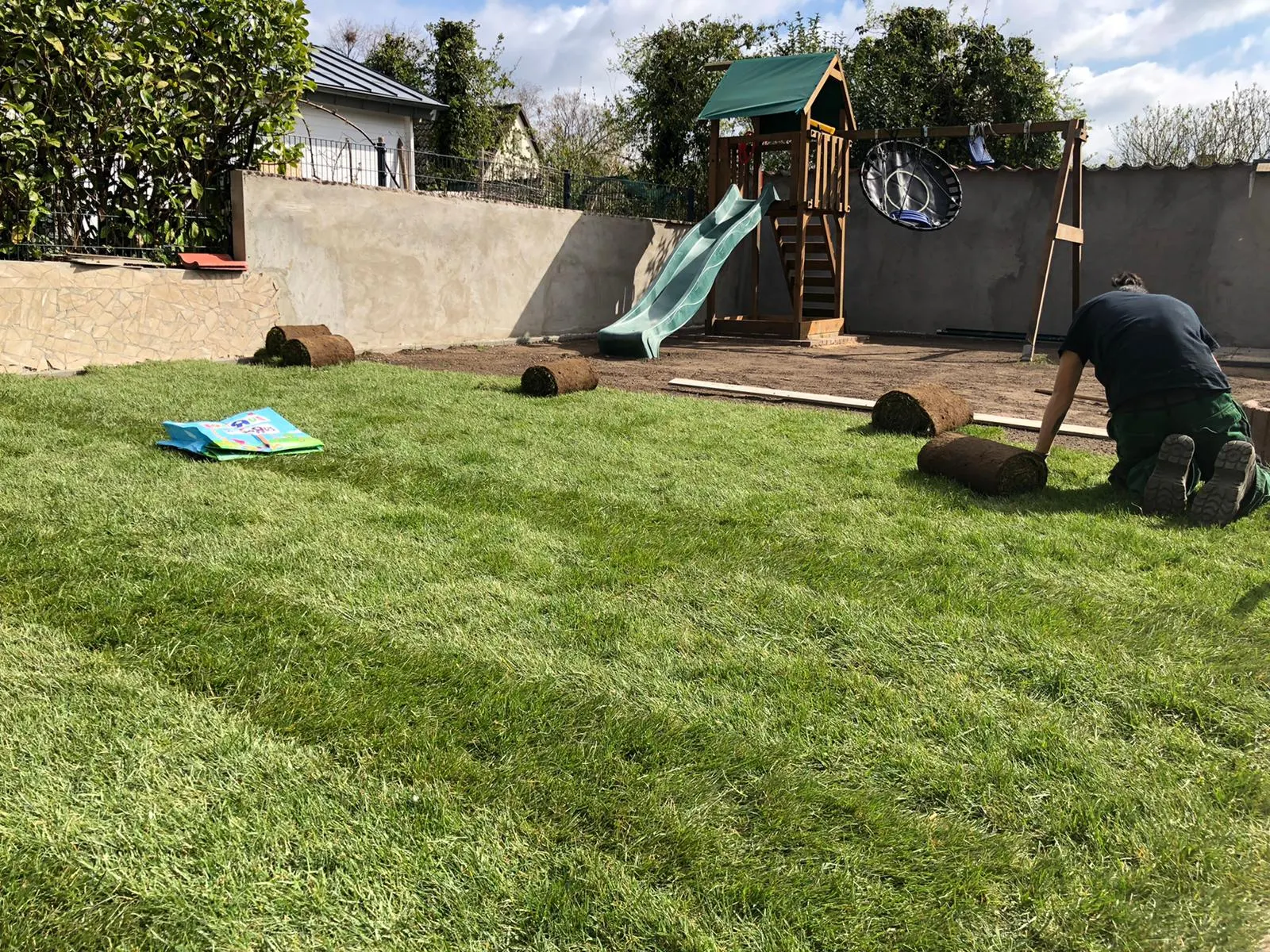 Frisch verlegter Rollrasen im Garten mit Spielturm